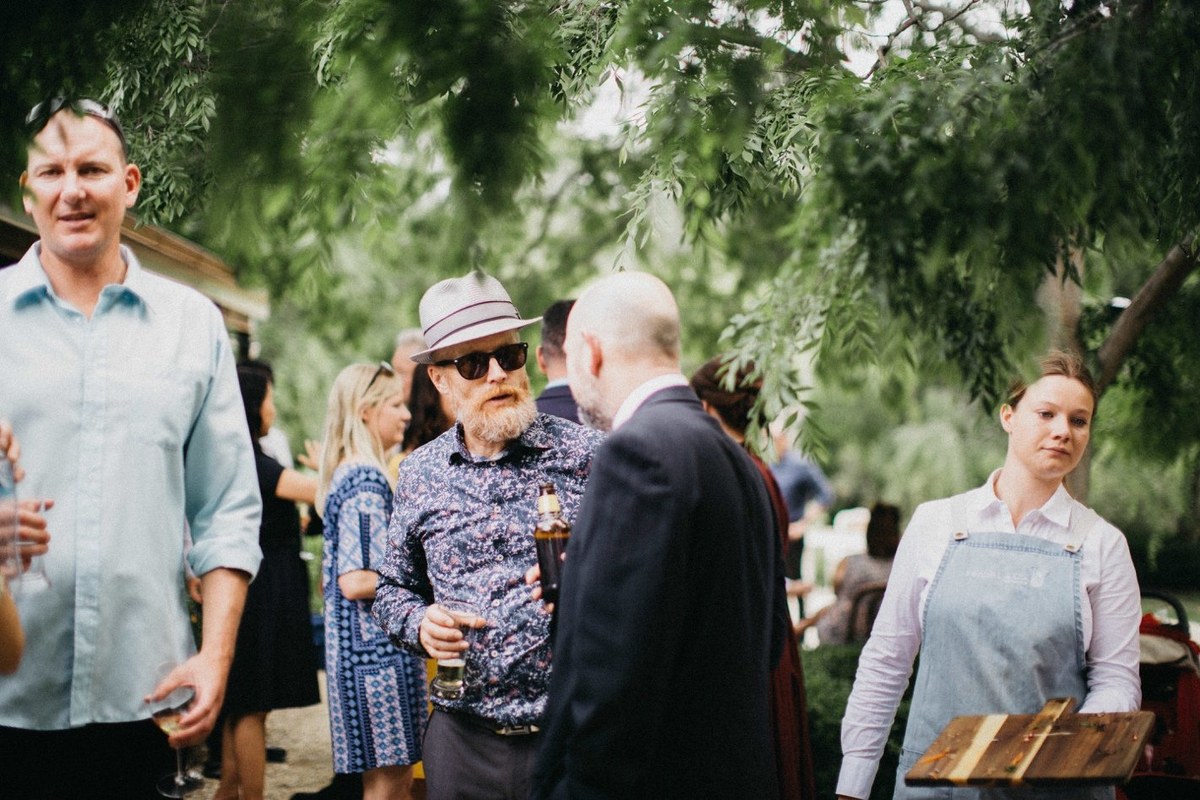 Guests greet one another in the garden before the reception. Photograph by documentary wedding photographer Joshua Mikhaiel.