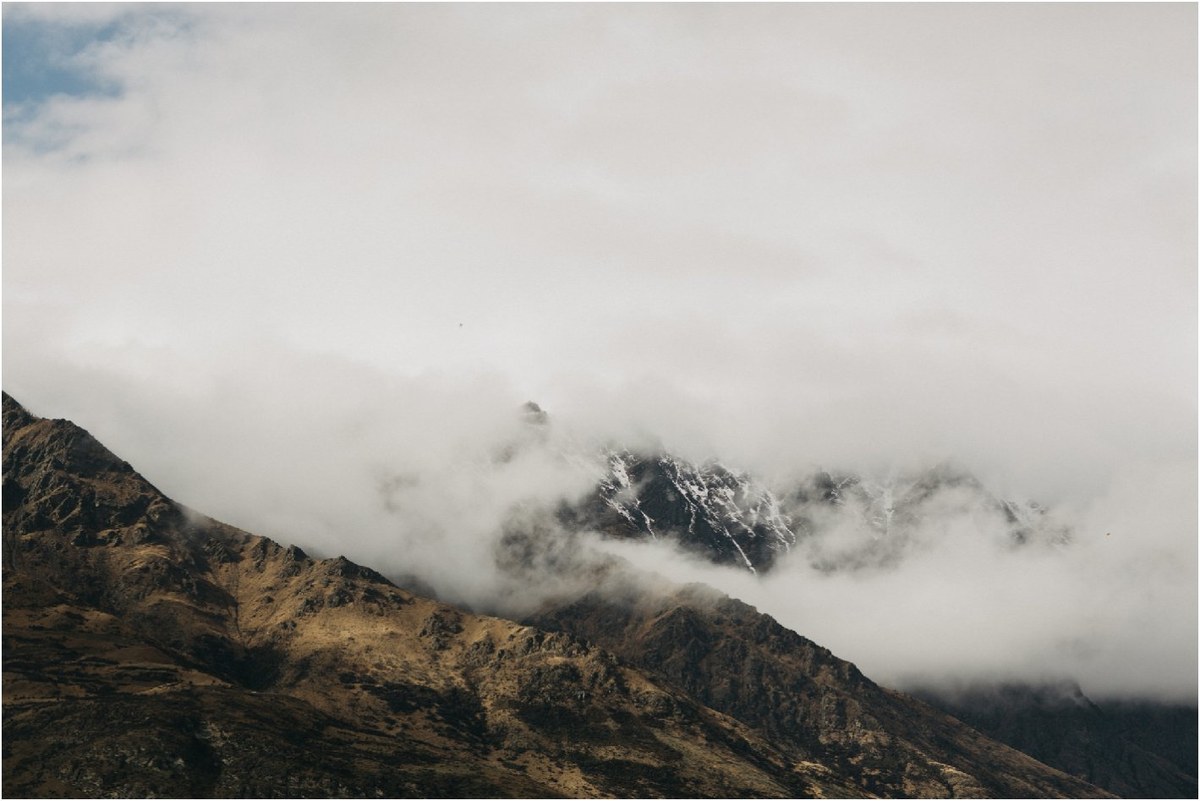Cloud wraps around a rugged mountain ridge on New Zealand’s South Island, photographed by documentary wedding photographer Joshua Mikhaiel.