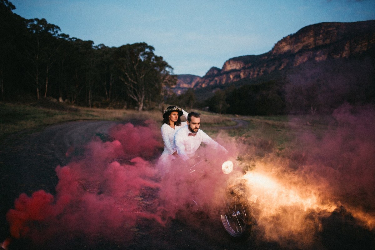 Couple portrait at a Gold Coast wedding venue A couple stand together as colored smoke drifts across the landscape.