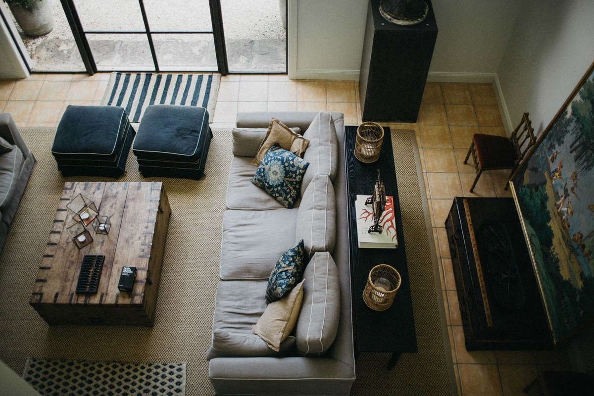 A living room is viewed from above, with sofas arranged around a low table. Photograph by documentary wedding photographer Joshua Mikhaiel.