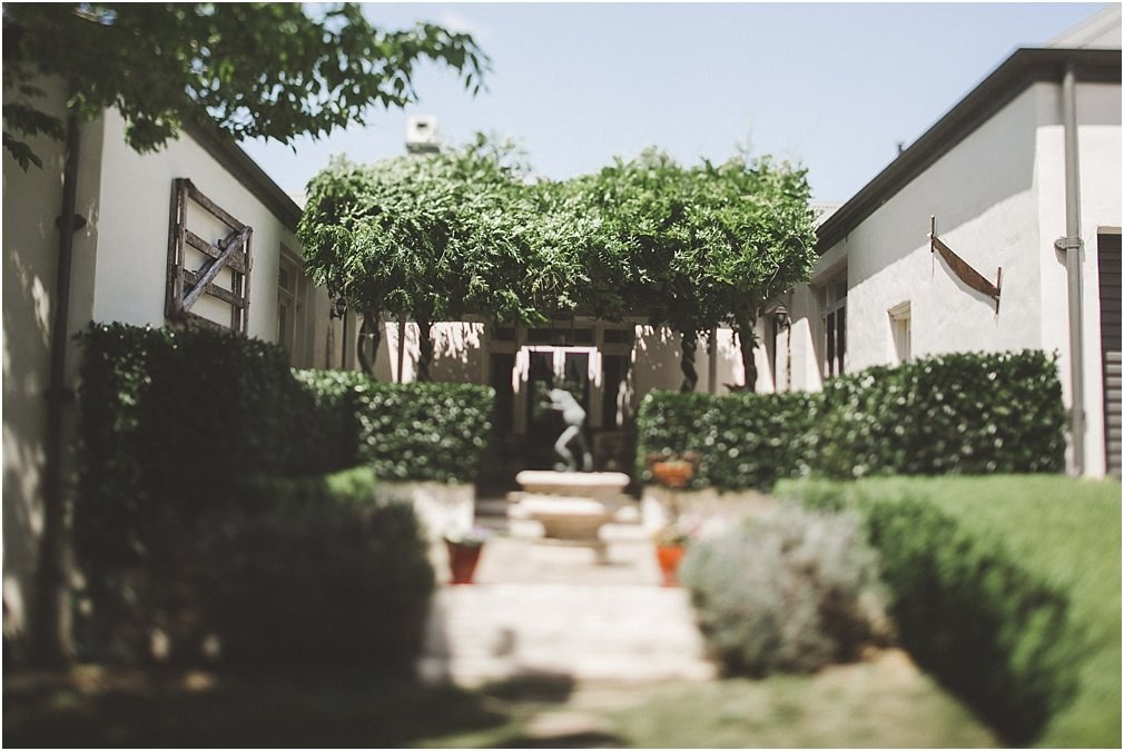 Courtyard at the wedding venue — Joshua Mikhaiel, documentary wedding photographer A small paved courtyard with outdoor seating and a tree at its centre, photographed by documentary wedding photographer Joshua Mikhaiel.