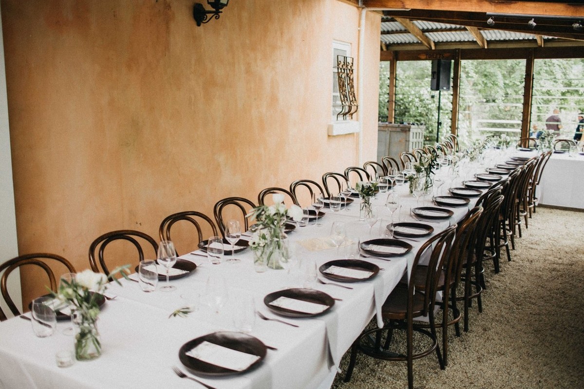 Long reception tables are arranged in the homestead dining room. Photograph by documentary wedding photographer Joshua Mikhaiel.
