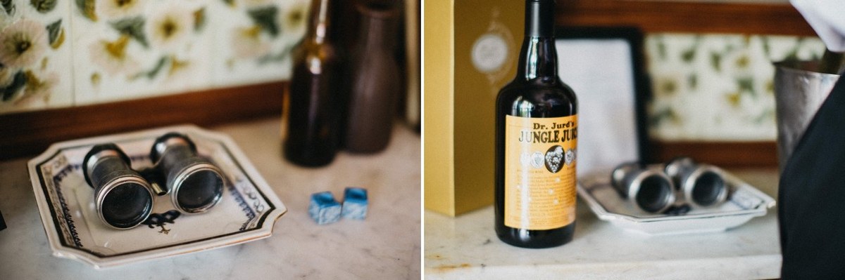 A grooming kit and bottle of whiskey are arranged on a table. Photograph by documentary wedding photographer Joshua Mikhaiel.
