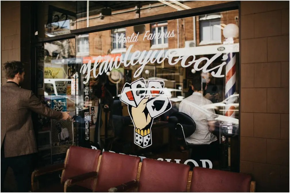 Shopfront with hand-painted signage at Carriageworks — Joshua Mikhaiel, documentary wedding photographer A passerby looks through the window of a shop with a hand-painted sign, photographed by documentary wedding photographer Joshua Mikhaiel.