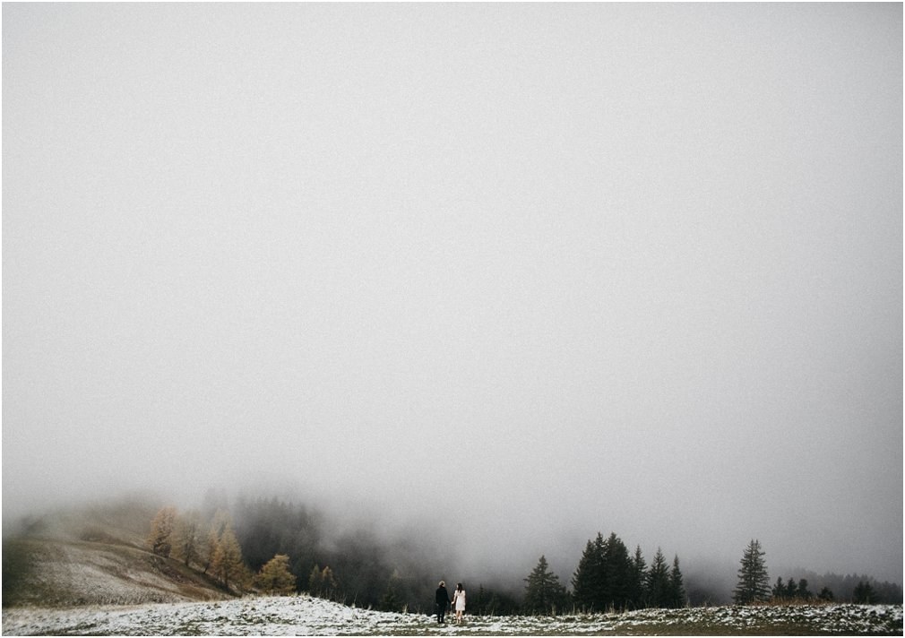 Clouds over a Swiss alpine hillside — Joshua Mikhaiel, documentary wedding photographer Low cloud drifts across a snow-dusted alpine hillside and evergreen forest, photographed by documentary wedding photographer Joshua Mikhaiel.