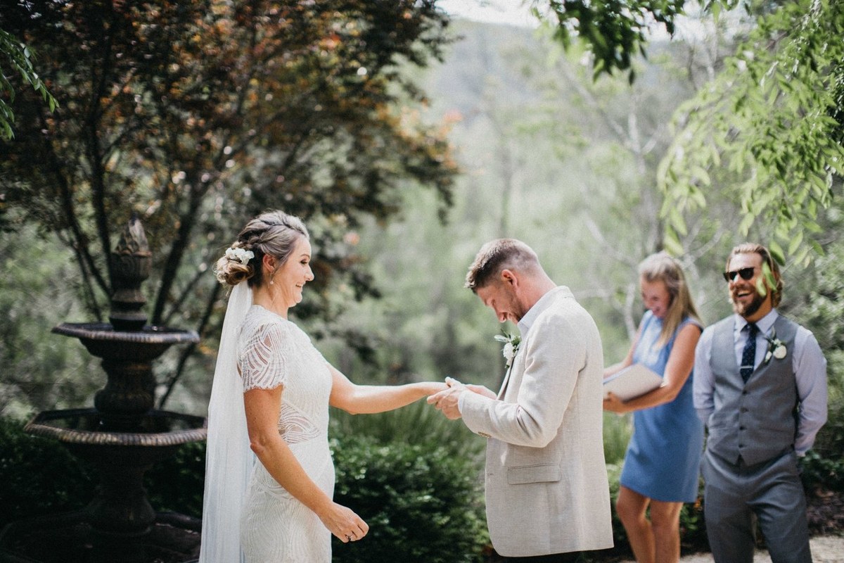 The bride and groom hold hands as the officiant leads the ceremony. Photograph by documentary wedding photographer Joshua Mikhaiel.