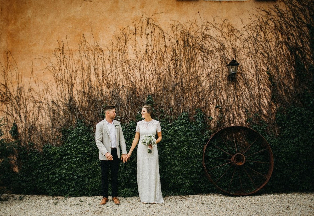 The bride and groom pose beneath a tree in the golden grass. Photograph by documentary wedding photographer Joshua Mikhaiel.