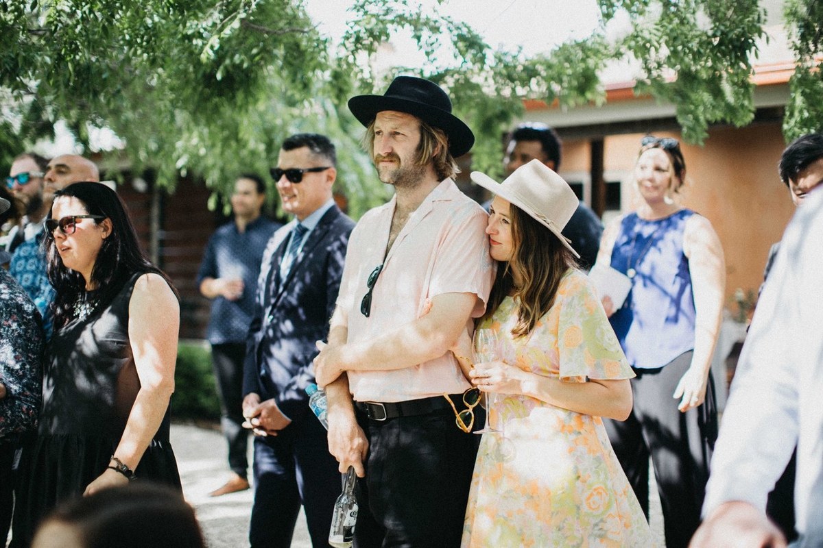 Guests watch the ceremony from beneath the trees. Photograph by documentary wedding photographer Joshua Mikhaiel.