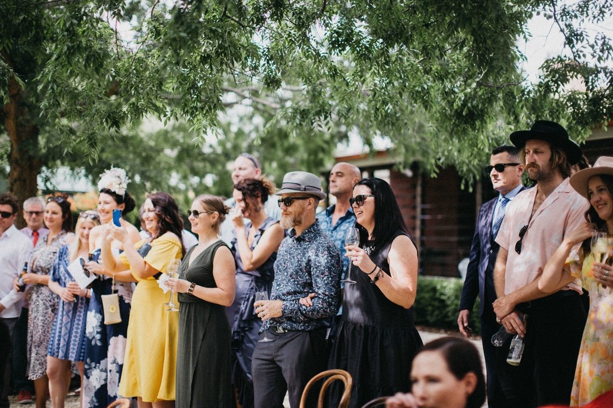 Guests sit among the trees as the outdoor ceremony begins. Photograph by documentary wedding photographer Joshua Mikhaiel.