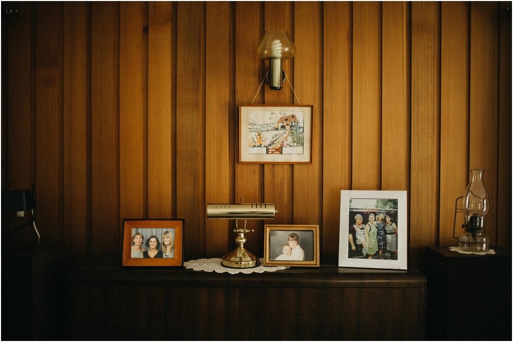 Family photographs on a shelf — Joshua Mikhaiel, documentary wedding photographer Family photographs and keepsakes are arranged on a wooden shelf, photographed by documentary wedding photographer Joshua Mikhaiel.