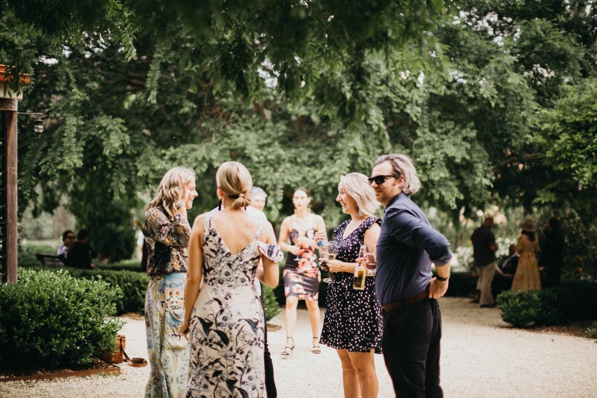 Guests mingle beneath the trees near the homestead. Photograph by documentary wedding photographer Joshua Mikhaiel.
