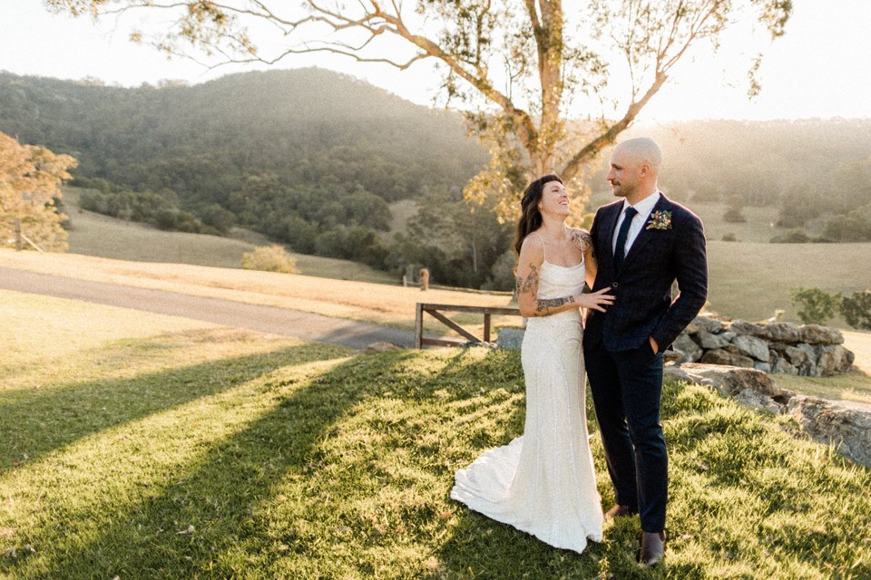 A bride and groom embrace on the lawn beneath the trees. Photograph by documentary wedding photographer Joshua Mikhaiel.