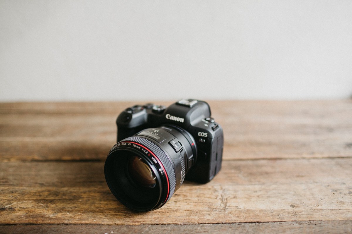 Canon EOS R6 sample photo camera — Joshua Mikhaiel, documentary wedding photographer A Canon camera sits on a wooden surface beside the beach. Photograph by documentary wedding photographer Joshua Mikhaiel.