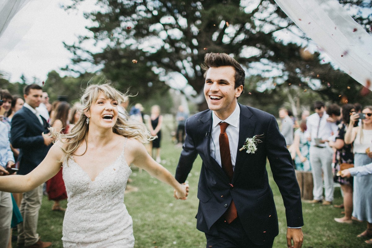 Newlyweds running through guests — Joshua Mikhaiel, documentary wedding photographer The bride and groom run between their guests after the ceremony. Photograph by documentary wedding photographer Joshua Mikhaiel.
