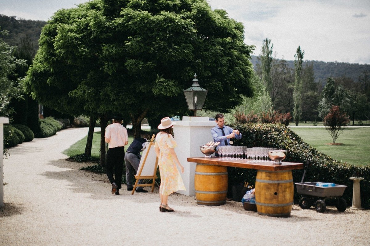 Wedding guests mingle outside the homestead before the ceremony. Photograph by documentary wedding photographer Joshua Mikhaiel.