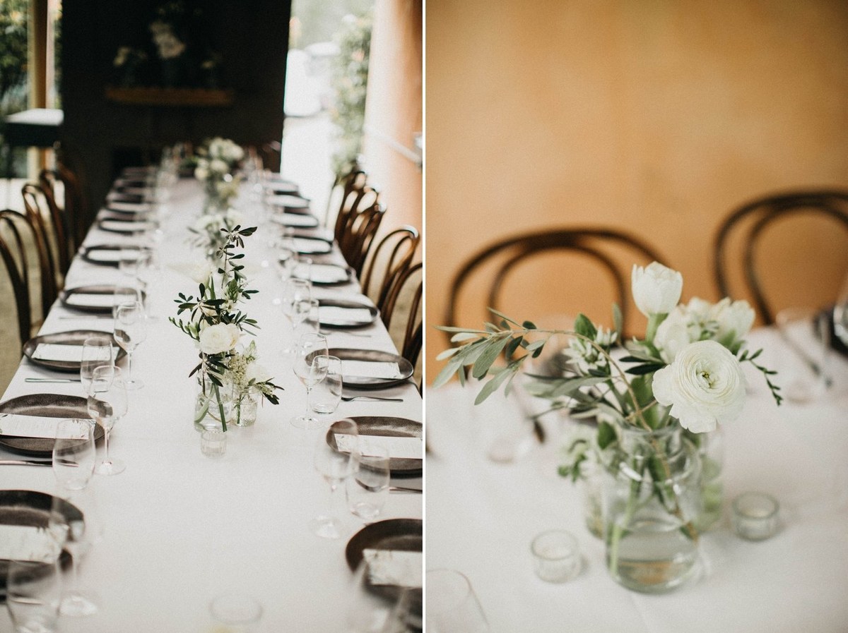 A long table is set with floral centerpieces and place settings. Photograph by documentary wedding photographer Joshua Mikhaiel.