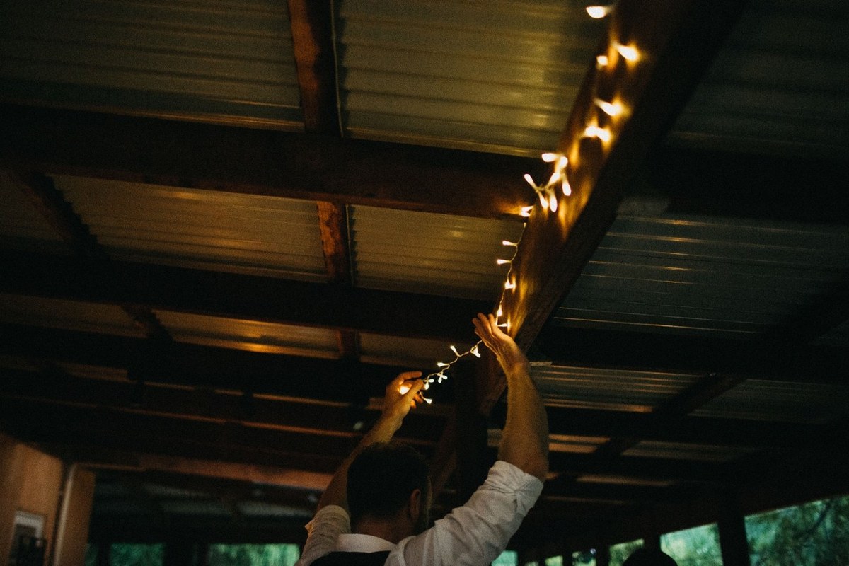 Guests sit together for dinner in the warmly lit reception room. Photograph by documentary wedding photographer Joshua Mikhaiel.