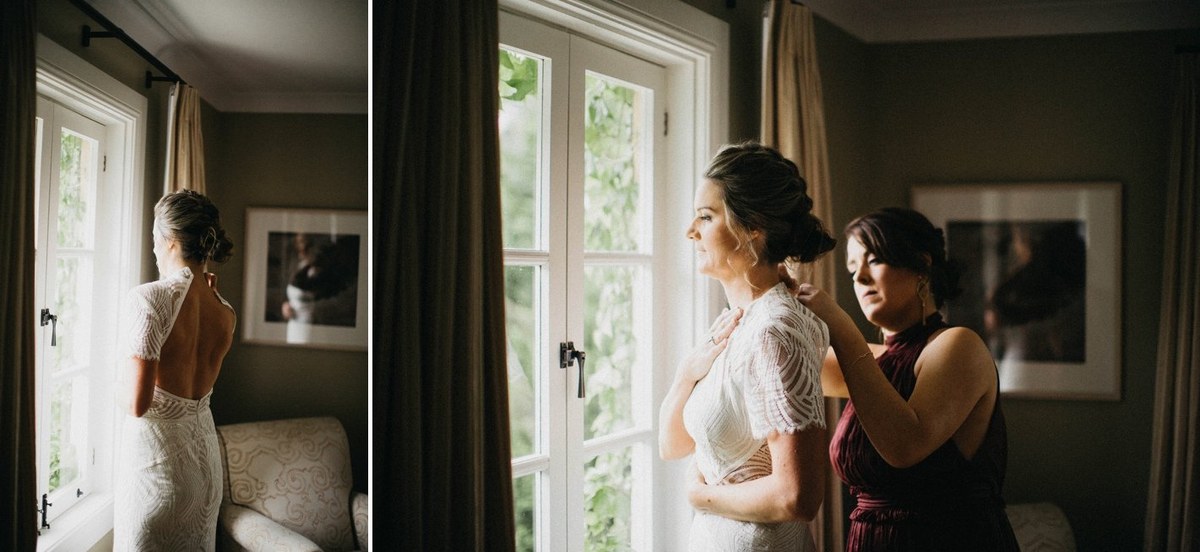 An attendant helps the bride prepare beside the bedroom window. Photograph by documentary wedding photographer Joshua Mikhaiel.