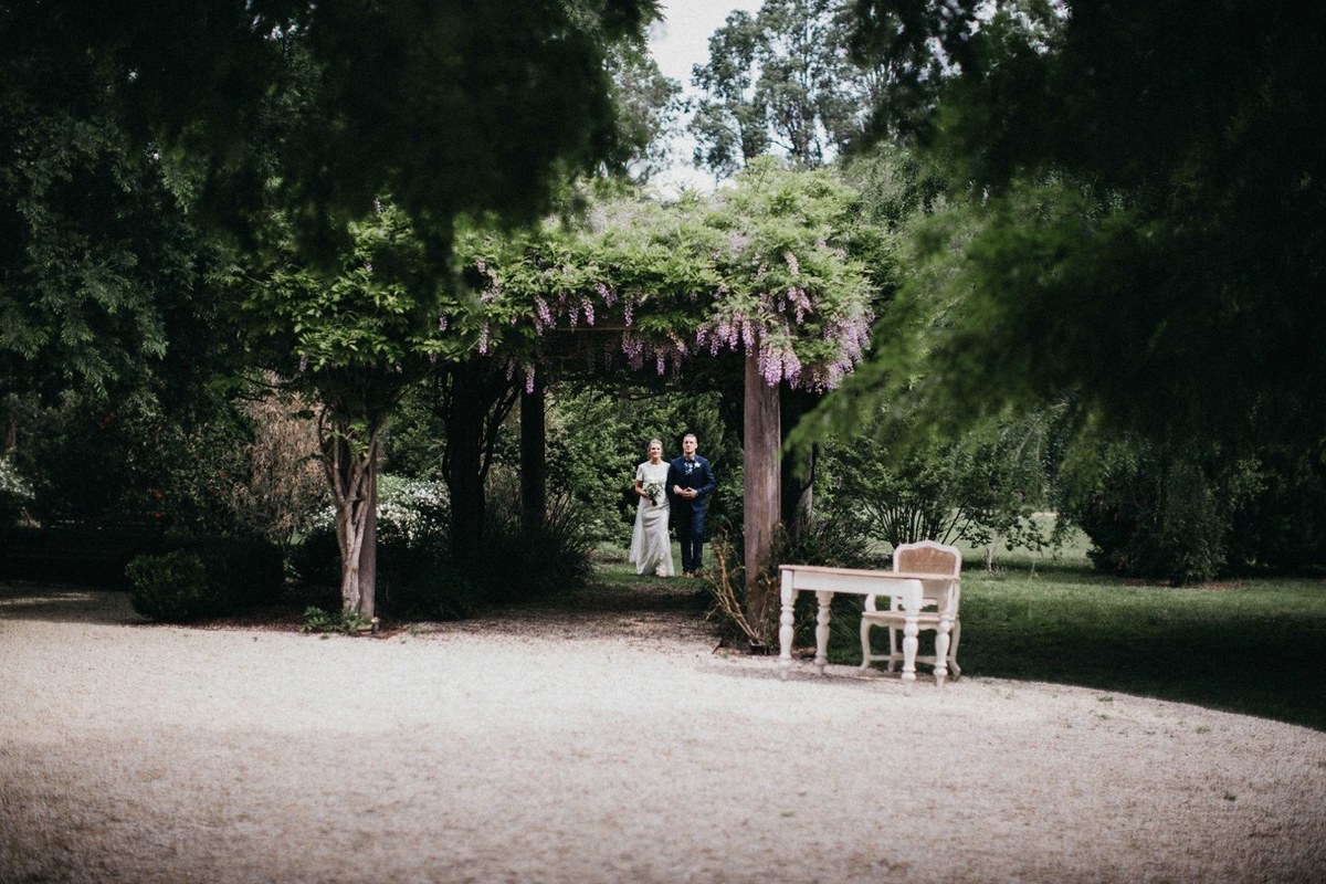 The bride and groom pose with a guest in the garden. Photograph by documentary wedding photographer Joshua Mikhaiel.
