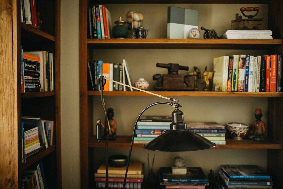 Books, ornaments and a desk fill a timber bookshelf. Photograph by documentary wedding photographer Joshua Mikhaiel.