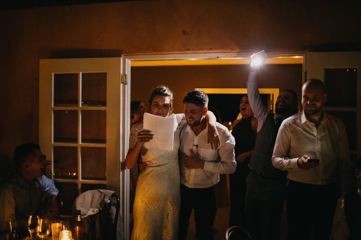 A guest holds an illuminated device above the crowd. Photograph by documentary wedding photographer Joshua Mikhaiel.